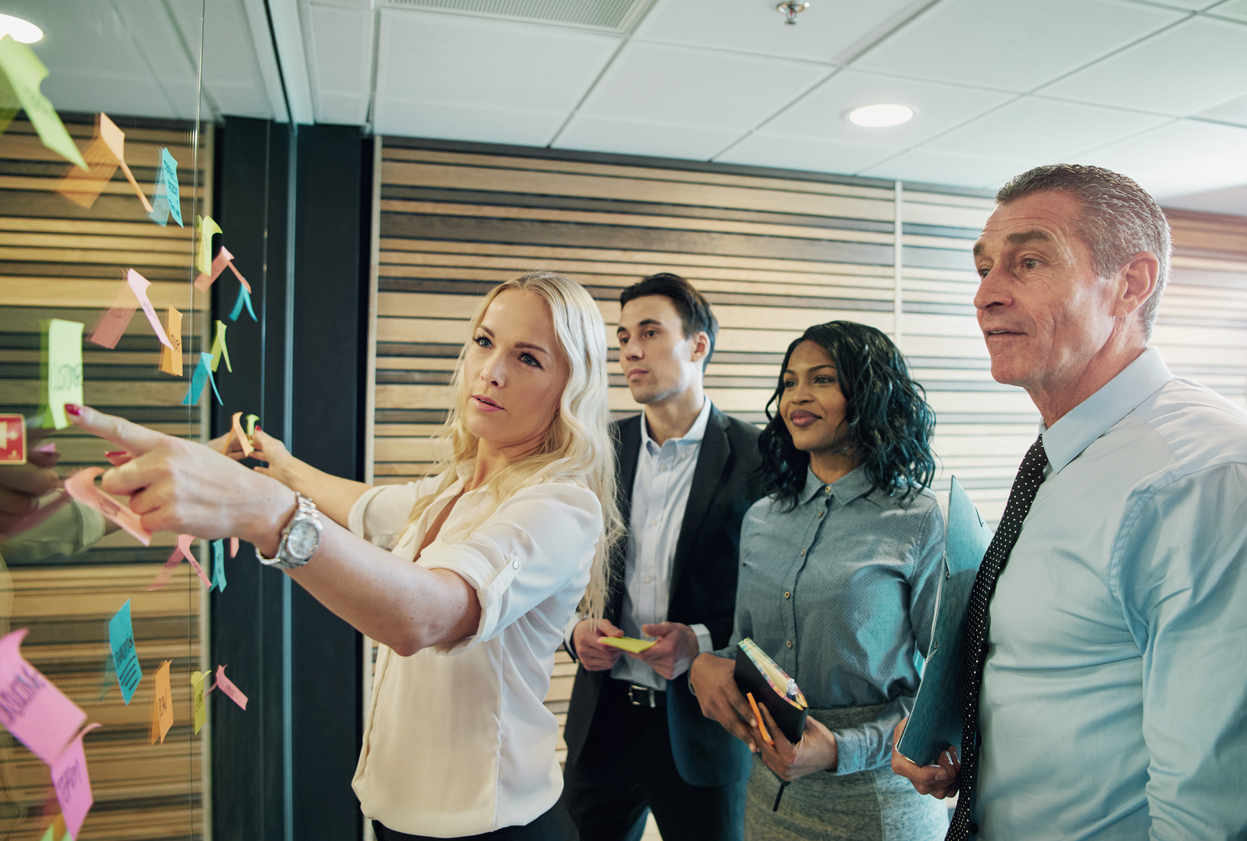 Woman in the office communicating with the team while making a strategy.